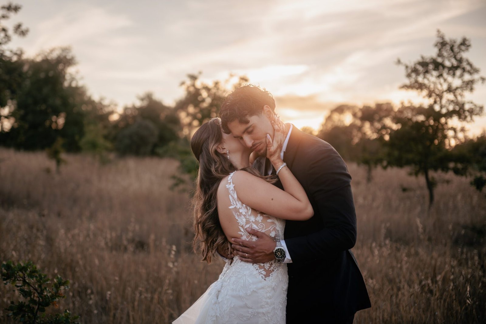 Un couple de mariés enlacé dans la lumière dorée du coucher de soleil